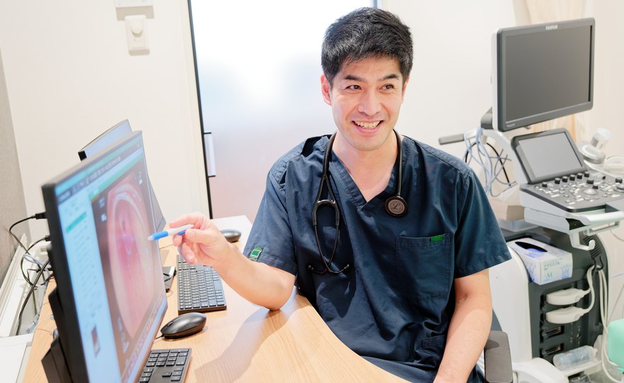 モニタで検査結果を説明する院長