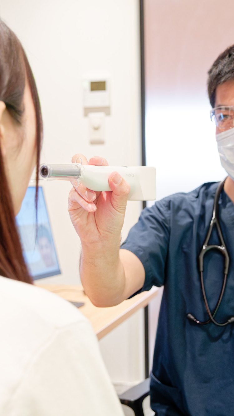 患者さまに検査機器を説明する院長