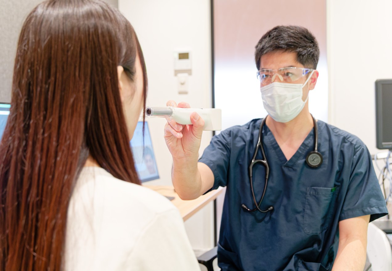 患者さまに検査機器を説明する院長